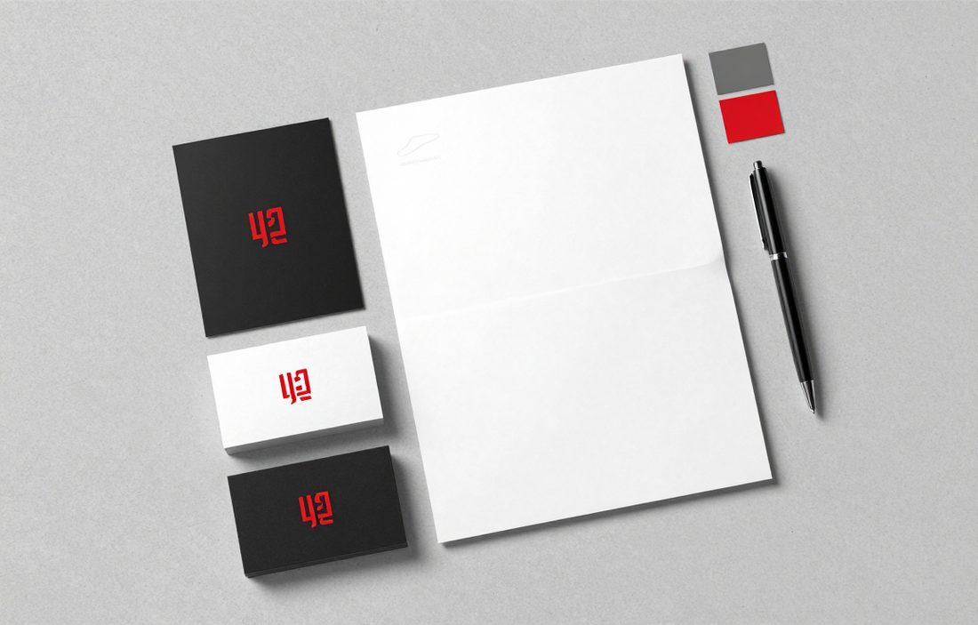 Identyfikacja wizualna firmy: wizytówki, papier firmowy i próbniki kolorów z czerwonym znakiem logo